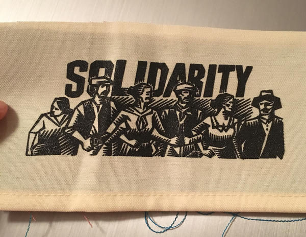 bold text with a woodcut drawing of a crowd of people hugging